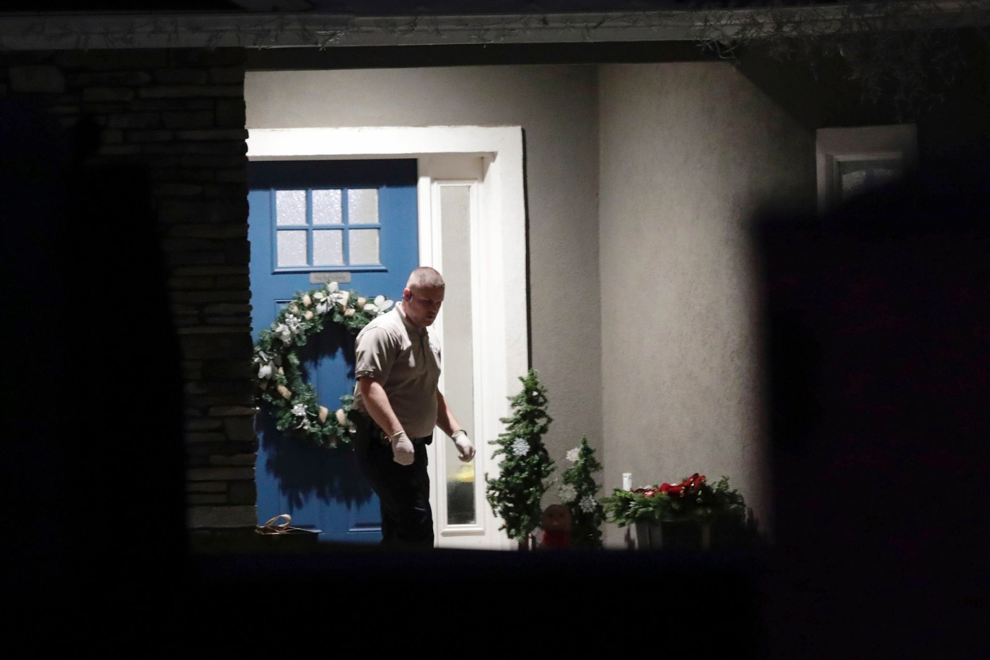 Ein Beamter der Strafverfolgungsbehörden vor dem Eingang eines Hauses in Utah, in dem acht Menschen tot aufgefunden worden sind.