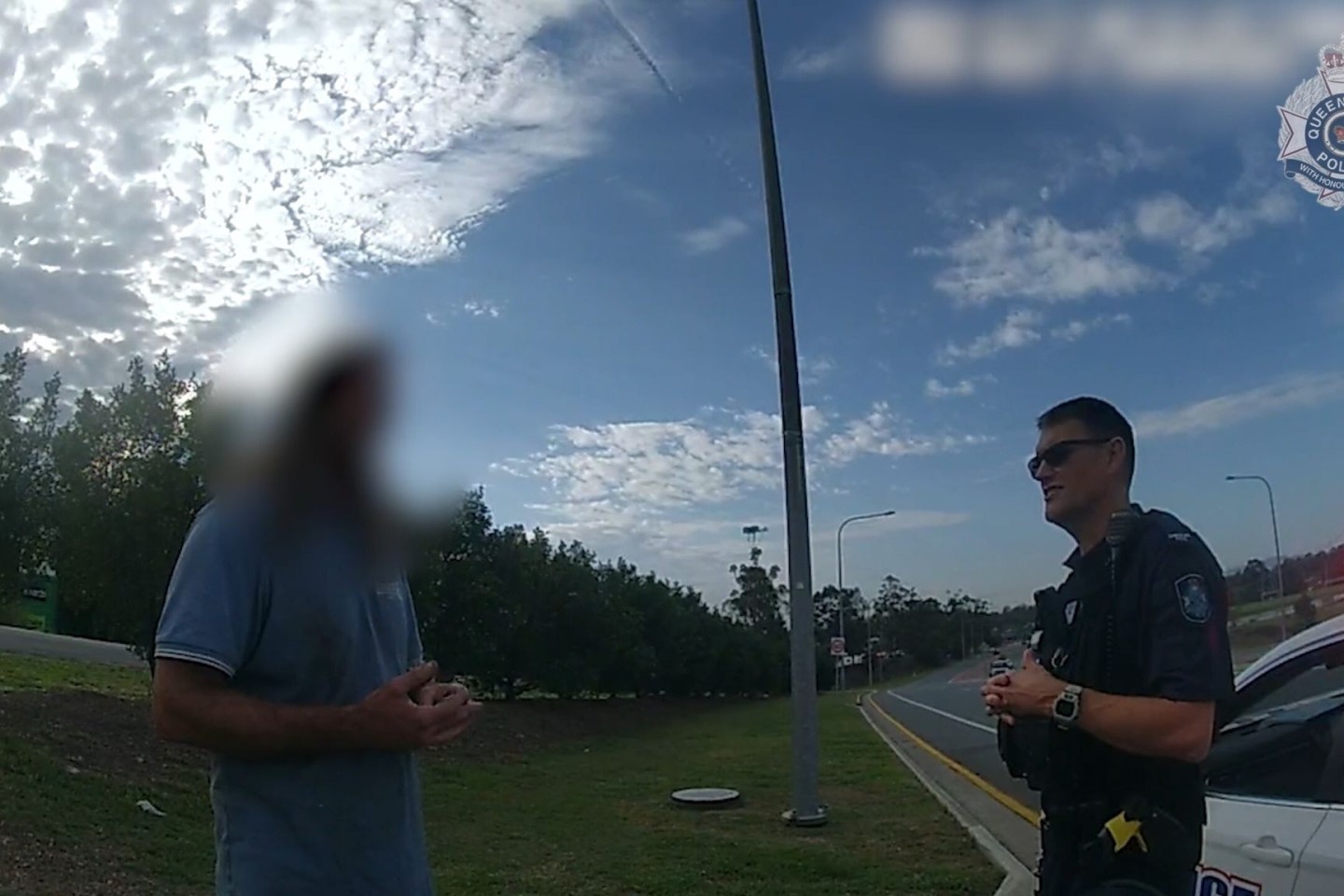 Ein Videostandbild der Polizei Queensland zeigt den Mann im Gespräch mit einem Beamten.
