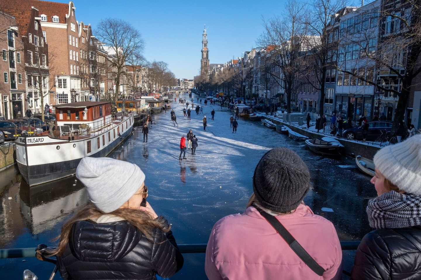Dutzende von Schlittschuhläufern laufen auf der gefrorenen Oberfläche von Amsterdams historischem Prinsengracht-Kanal.