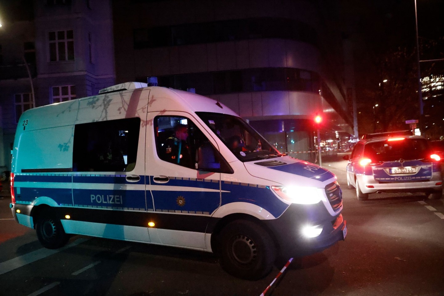 Einsatzfahrzeuge der Polizei am Tatort in Berlin, wo ein Geschäft überfallen wurde.
