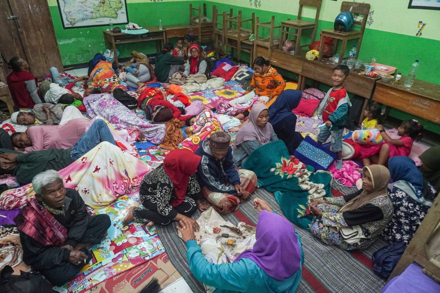 Menschen suchen in einer Schule Schutz, die nach dem Ausbruch des Vulkans Semeru als vorübergehende Unterkunft für die aus ihren Häusern Evakuierten dient.