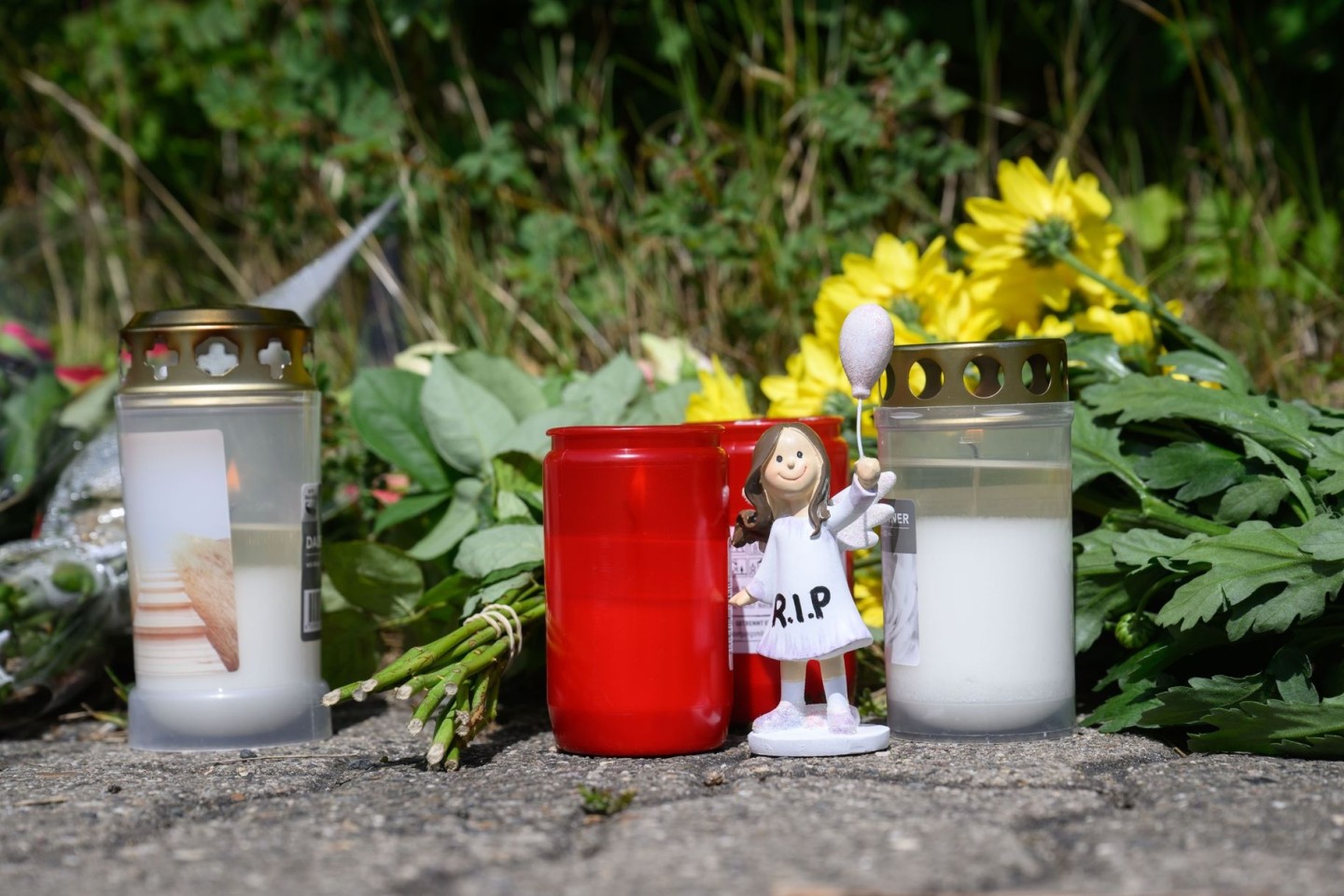 Kerzen, Blumen und Figuren zum Gedenken an eine getötete 15-jährige liegen am Tatort an einer Grünfläche in Salzgitter. Ein 13-Jähriger und ein 14-Jähriger sollen das Mädchen getötet...