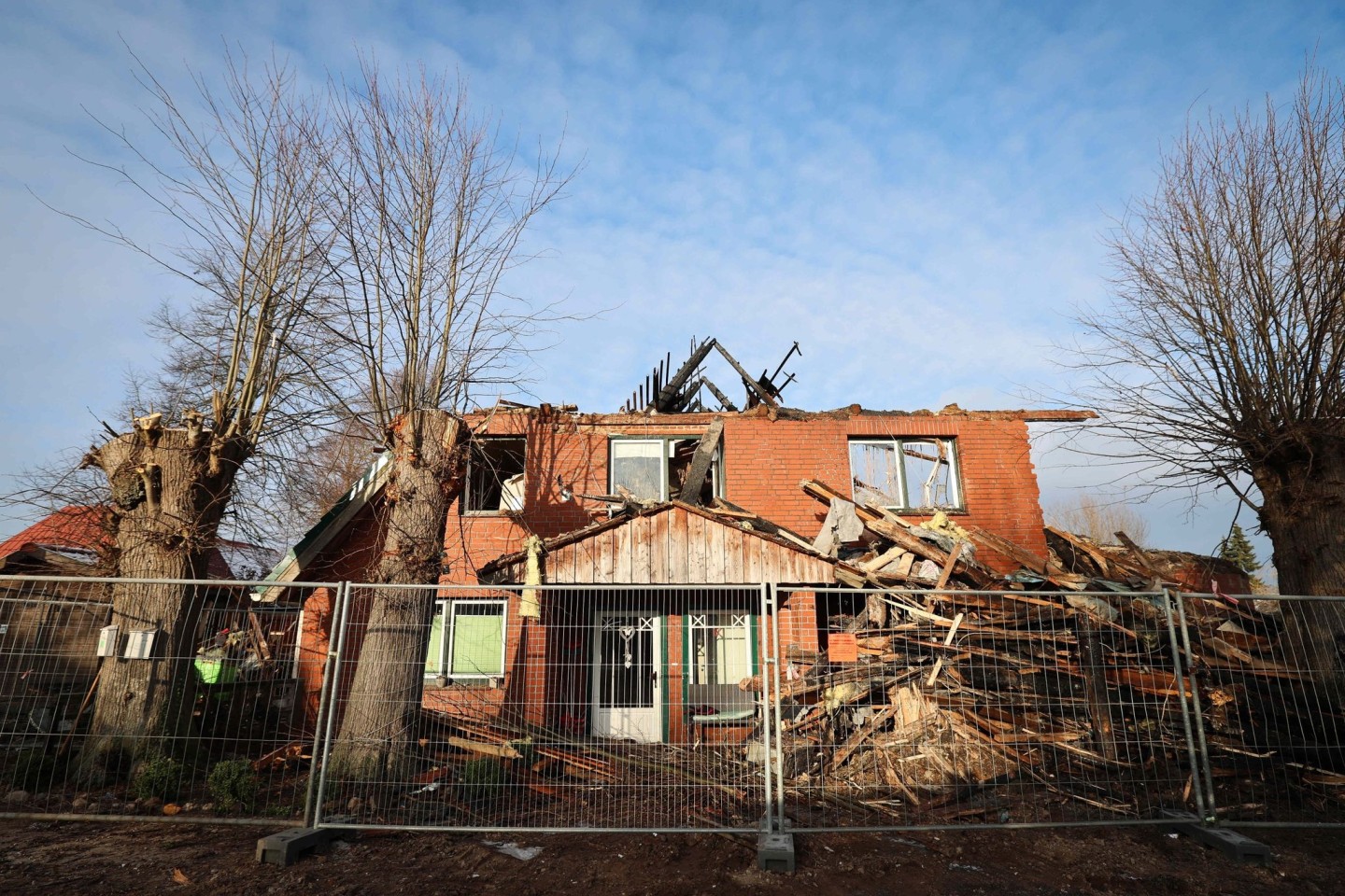 Ein Zaun der Landespolizei Schleswig-Holstein sichert das abgebrannte Haus, in dem zwei junge Menschen ums leben kamen.