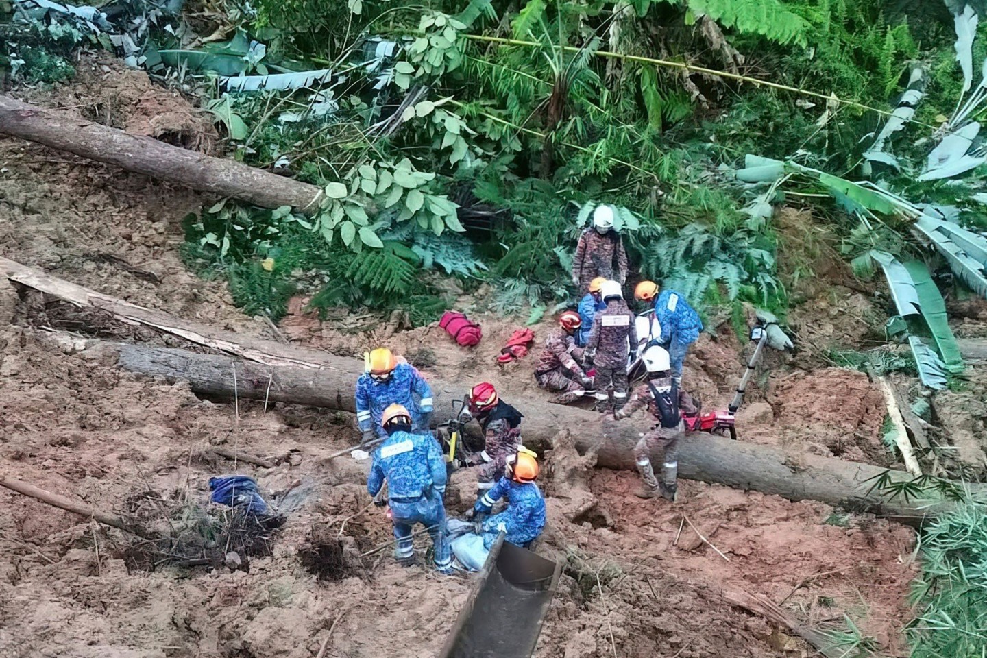Mitarbeiter des Zivilschutzes suchen in Batang Kali nach Überlebenden.
