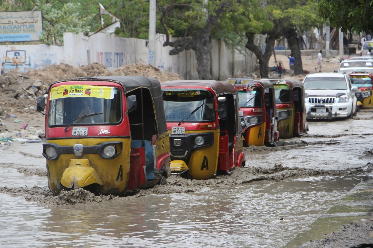 Tuktuks fahren durch eine überflutete Straße nach starkem Regen in Mogadischu.