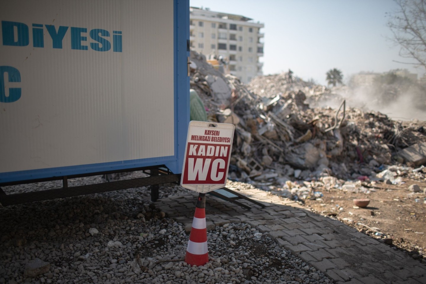 Eine von der Gemeinde Kayseri bereitgestellte mobile Toilette für Frauen steht neben einem eingestürzten Gebäude im türkischen Kahramanmaras.