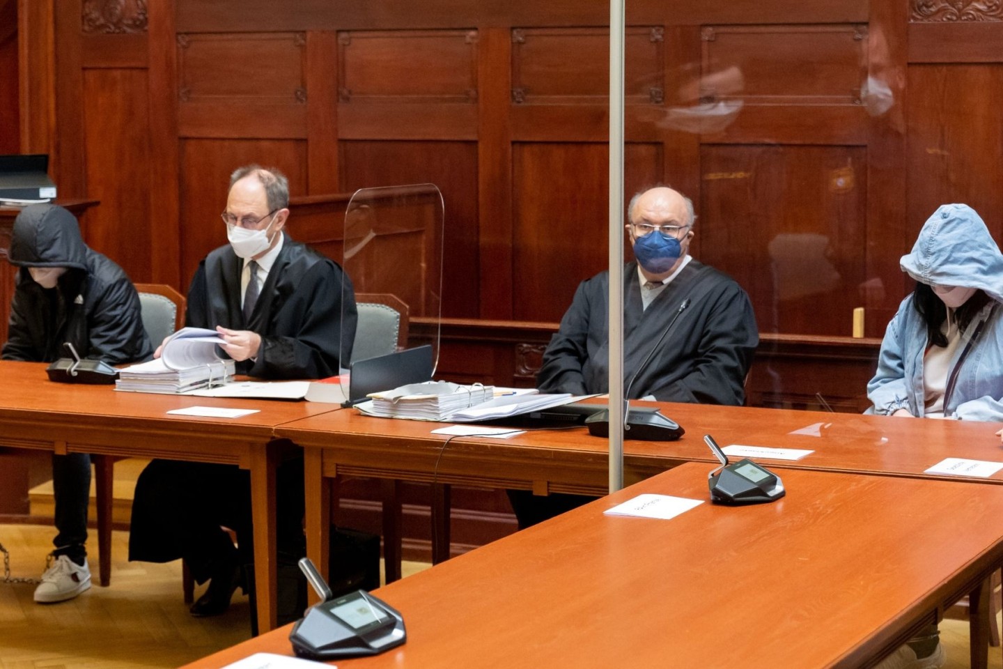 Eine angeklagte junge Frau (r) und ein angeklagter junger Mann (l) sitzen vor Prozessbeginn im Sitzungssaal im Landgericht Bayreuth (Archivbild).