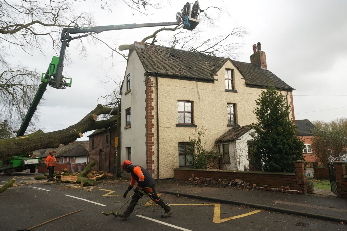 Arbeiter entfernen einen umgestürzten Baum, der das Dach eines Hauses in Derbyshire beschädigt hat.