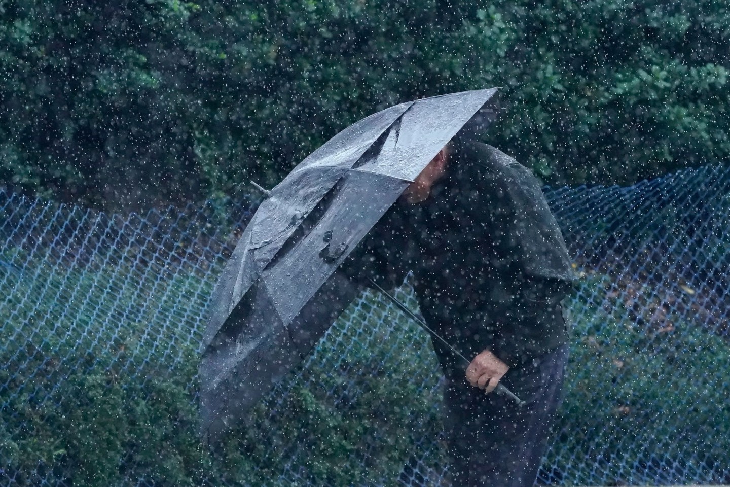 Ein Mann schützt sich in San Francisco vor Wind und Regen.