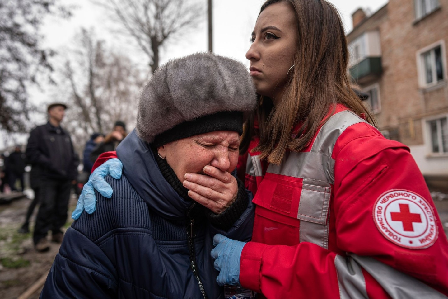 Eine Frau weint in den Armen einer Rettungskraft in der südostukrainischen Industriestadt Krywyj Rih.