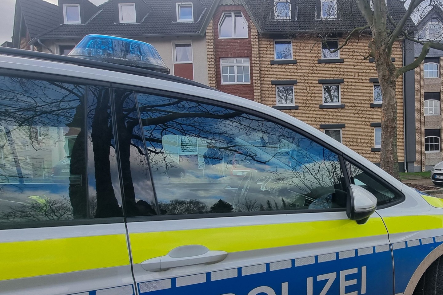 Ein Polizeiauto steht im Zuge von Ermittlungen vor einem Mehrfamilienhaus in Barsinghausen.