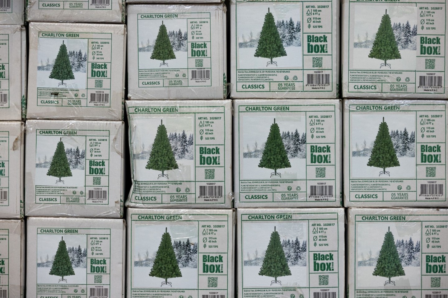 Verpackte Weihnachtsbäume aus Kunststoff (PVC) in einem Baumarkt.